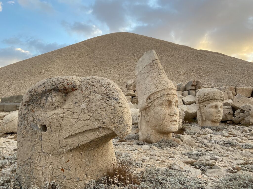 a group of stone statues in front of a pyramid